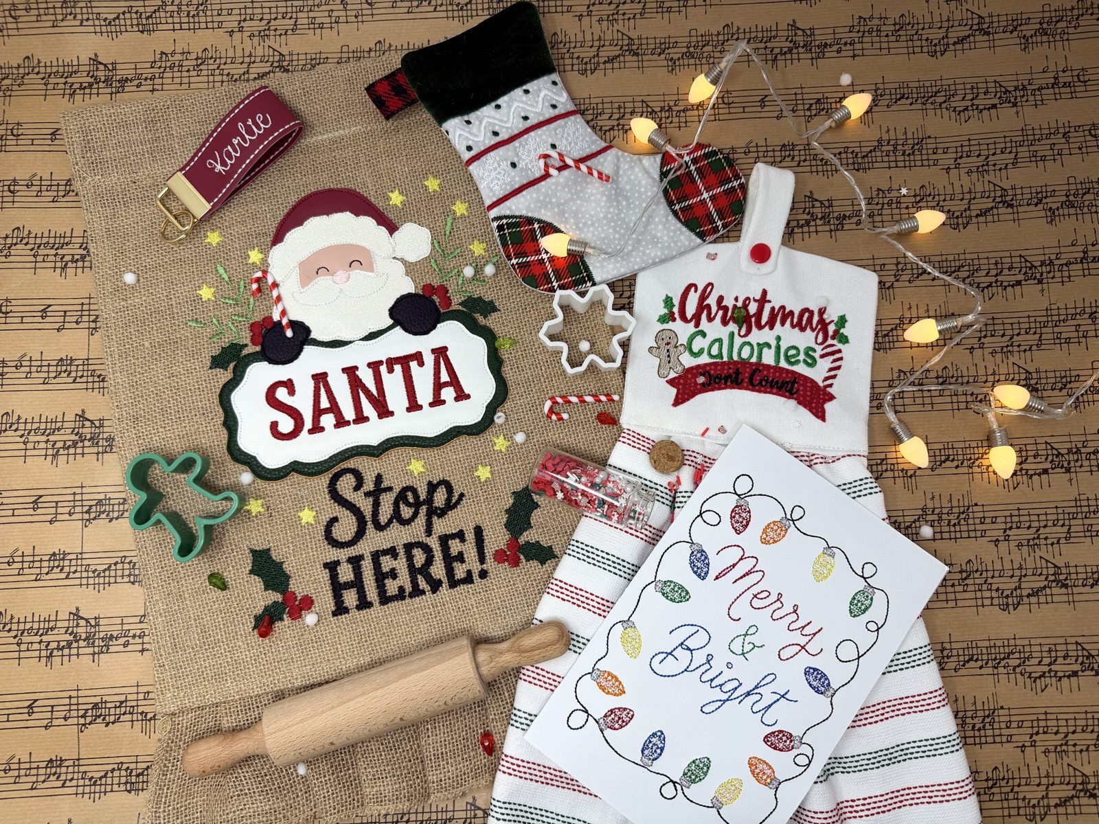 Five machine embroidery holiday projects from the 2026 Sip & Stitch Holiday Workshop: Santa Stop Here garden flag, in-the-hoop stocking, key fob, Christmas Calories towel topper, and Merry & Bright card